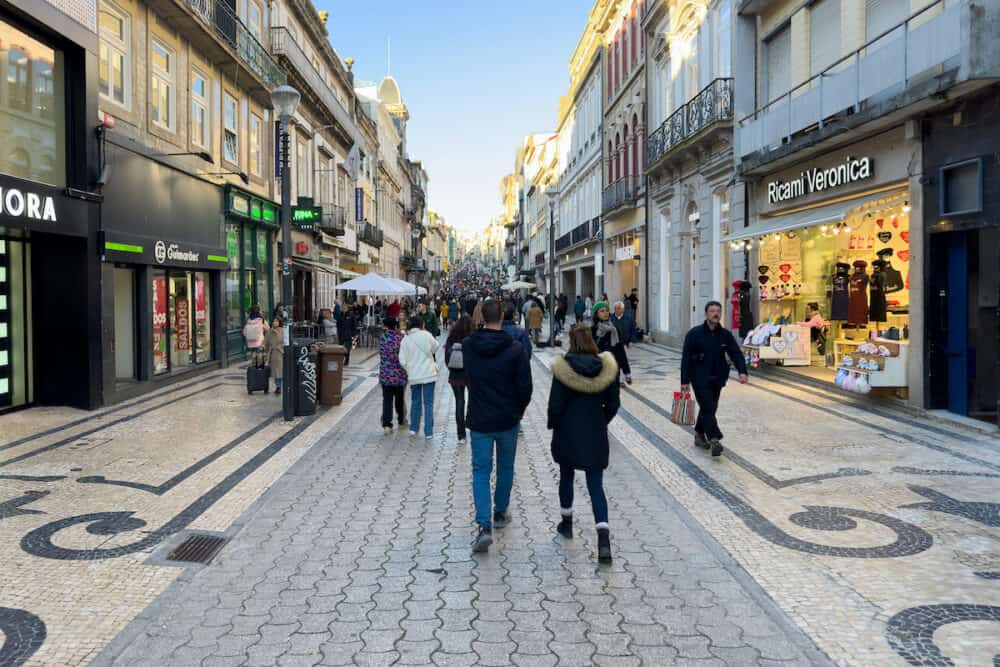 Tourists stroll along the main, mostly pedestrianized shopping street Santa Catarina in Porto, Portugal.