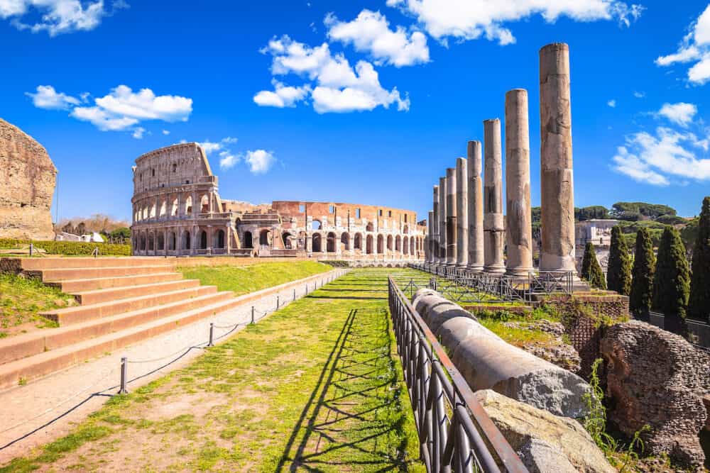 Colosseum in eternal city of Rome and Forum Romanum historic pillars view, famous landmark in capital of Italy