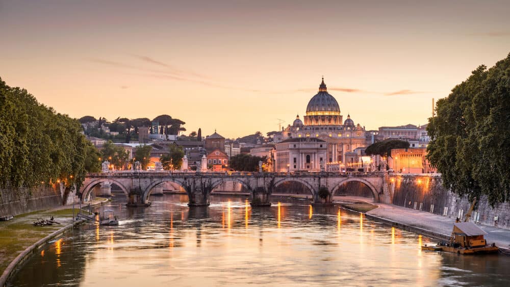 Rome at night, Italy. Sant`Angelo bridge and St Peter's Basilica. Rome landmark. Saint Peter's Basilica (San Pietro) is one of main travel attractions of Rome. Scenic night view of Rome and Vatican.