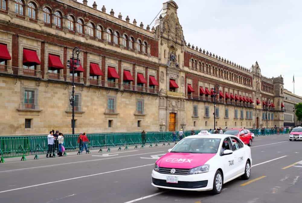 Typical pink taxis next to the National Palace in the historical center of Mexico City