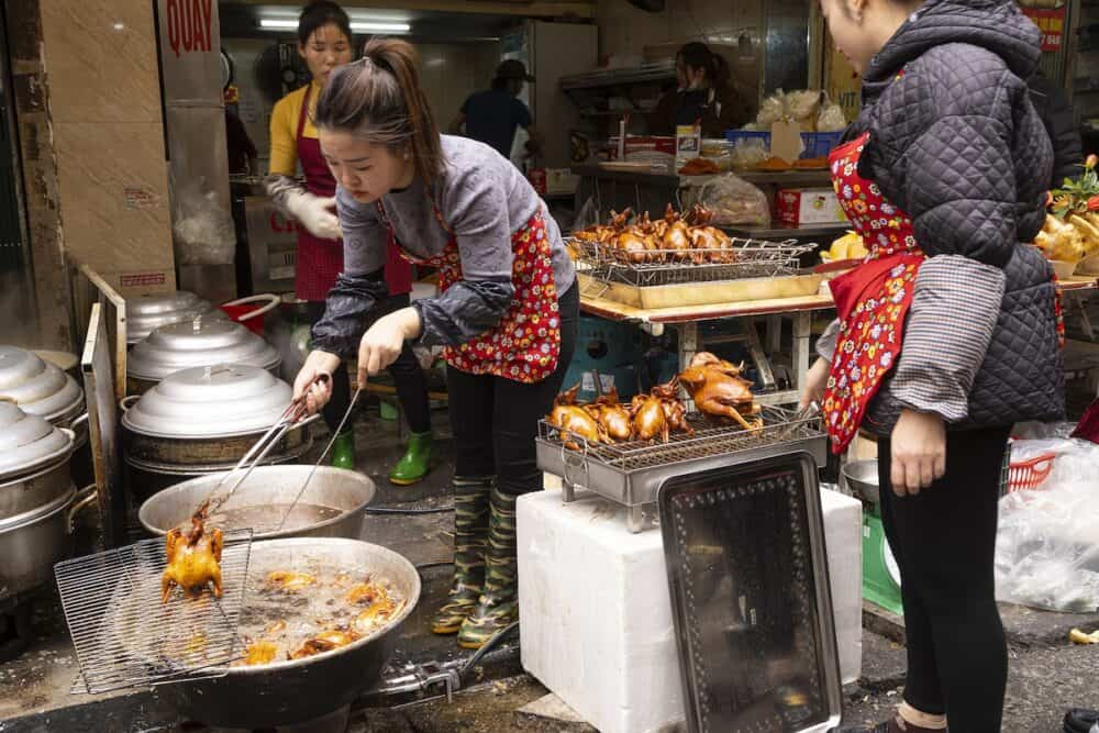the cooking of the traditional duck in a street in the city centre