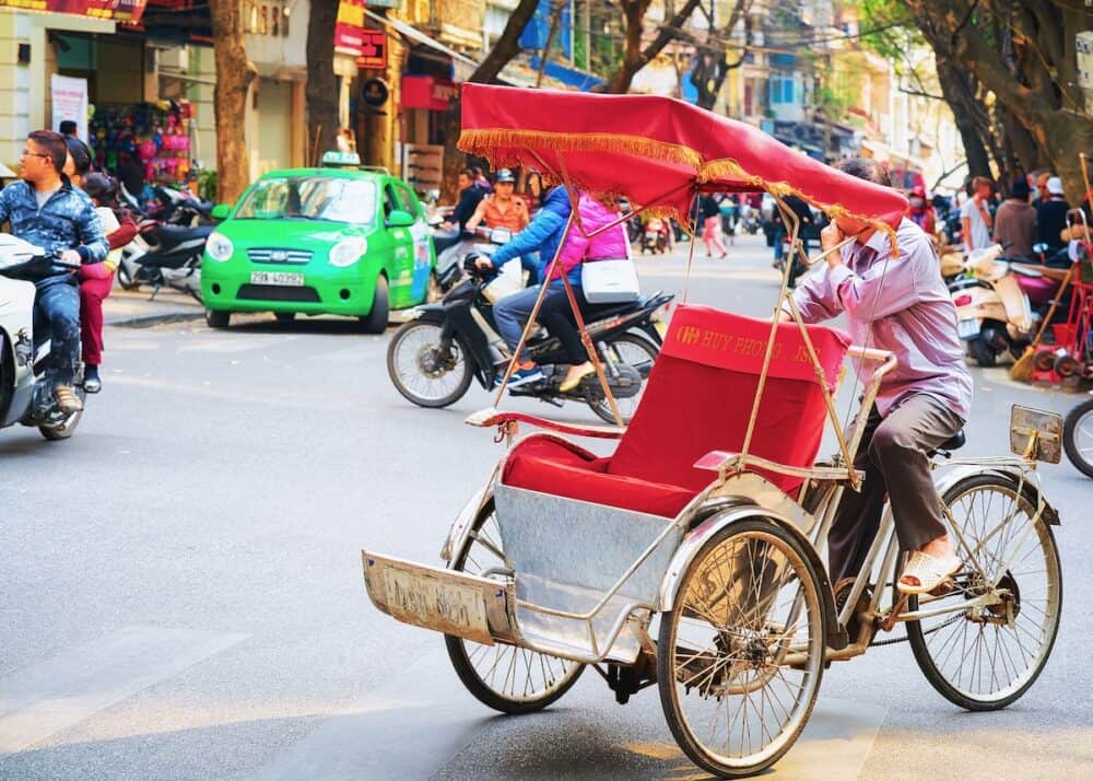 Cycle rickshaw on busy street in Hanoi, Vietnam