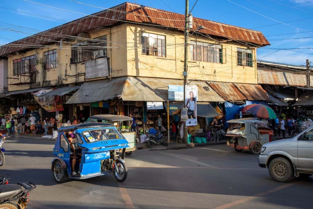 city landscape with tricycle and simple building of Chinese market. Filipino town travel and everyday life. Pedicab for passenger transportation.