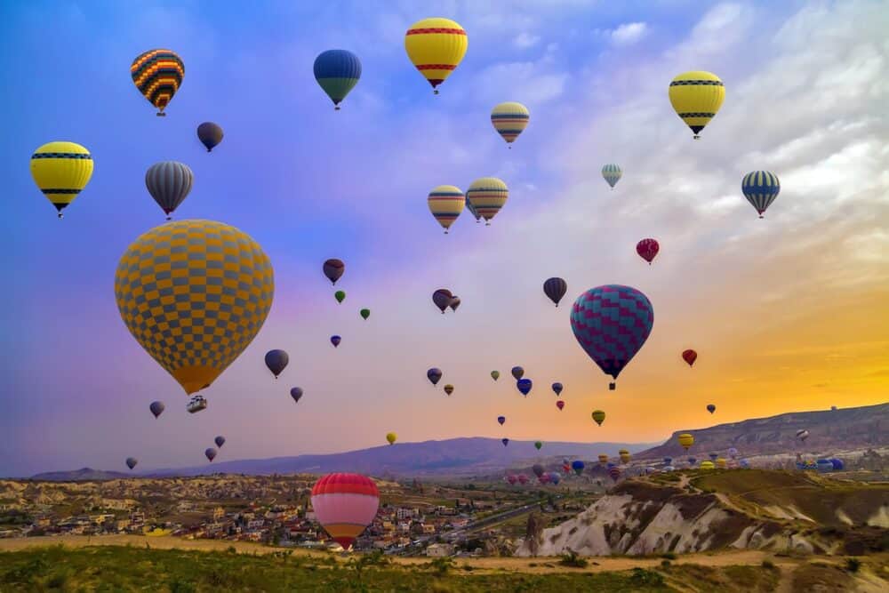 Hot Air balloons flying over Mountains landscape sunset Cappadocia Turkey