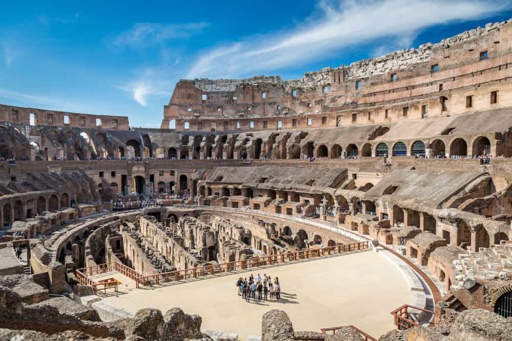 View of the inside of Colosseum in Rome Italy. 
Rome, Italy. Inside view of the Colosseum in Rome Italy April 22, 2015. Group of people in the foreground. 
Wide view of the Colosseum.