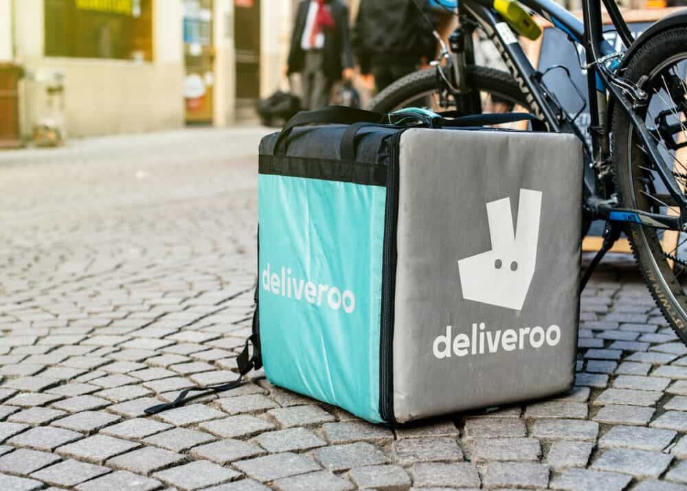 Detail of Deliveroo bike and cargo box parked in city. Deliveroo is a British online food delivery company