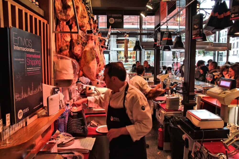 MADRID SPAIN - People visit Market of San Miguel (Spanish: Mercado de San Miguel) in Madrid. The market caters gourmet food tapas and alcohol.
