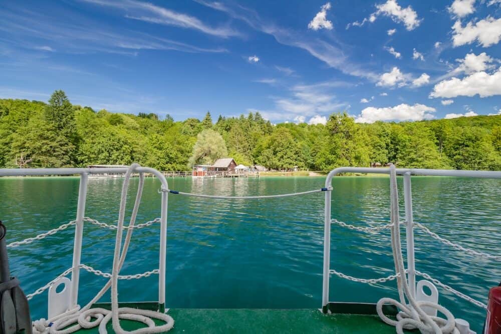 Plitvice Lakes, Croatia -  River boat at ferry moored to the pier at the turquoise colored crystal clear and pure Lake Kozjak, Plitvice Lakes National Park, Croatia.