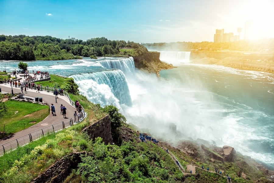 American side of Niagara falls NY USA. Tourists enjoying beautiful view to Niagara Falls during hot sunny summer day.