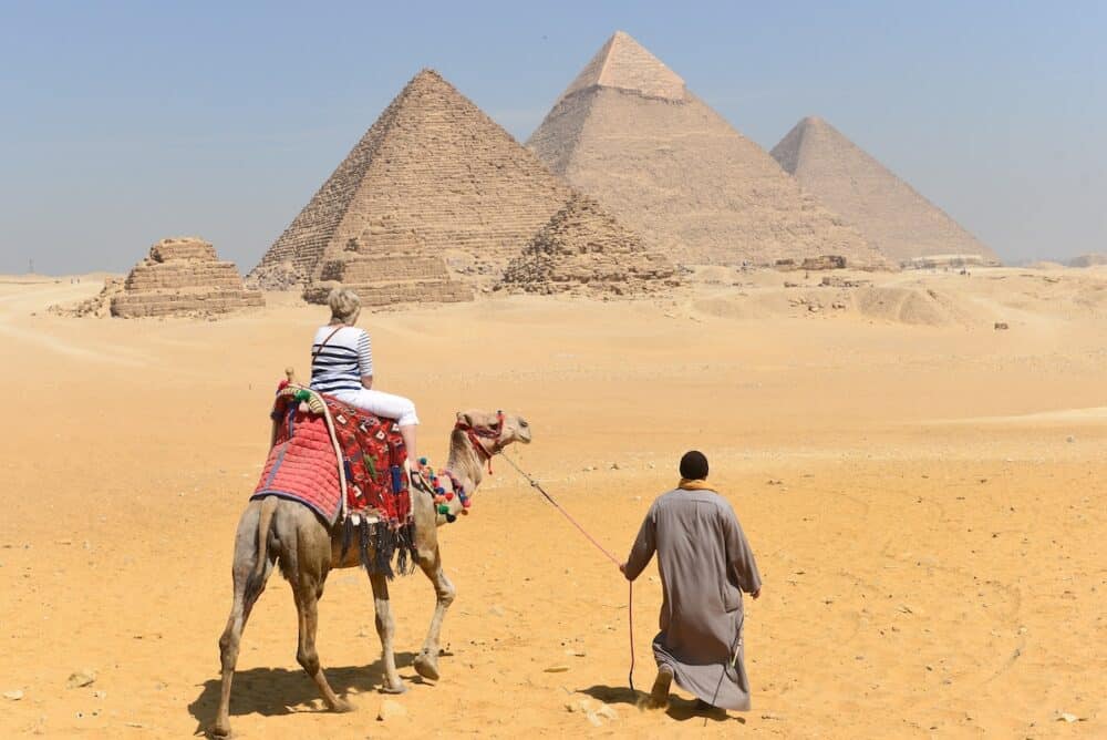 Tourists and  Giza Pyramids - Cairo, Egypt