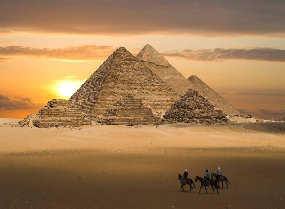 the pyramids of gizeh near cairo in egypt during a golden sunset.