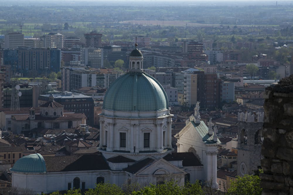 A picturesque aerial view of the iconic Brescia Cathedral dome amidst the cityscape of Brescia, Italy.