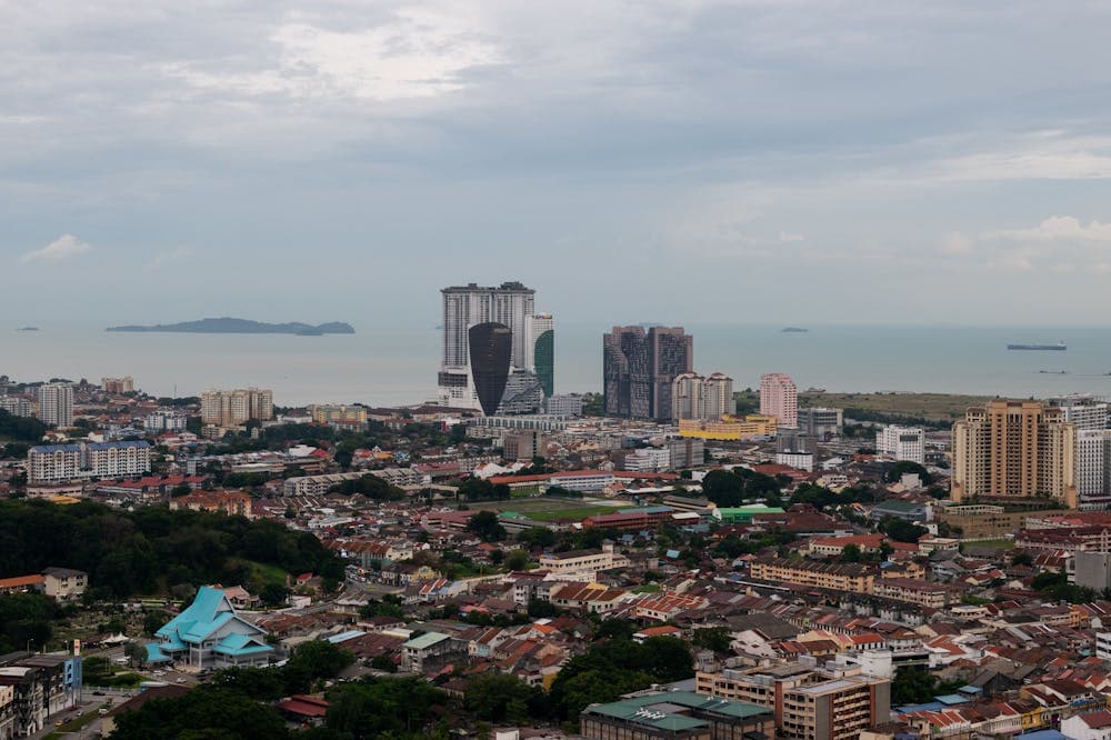 Breathtaking aerial shot of Melaka's skyline with modern skyscrapers and a serene ocean backdrop.