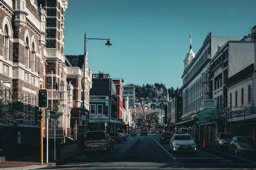 Historic urban street view in Dunedin with classic architecture and light traffic.
