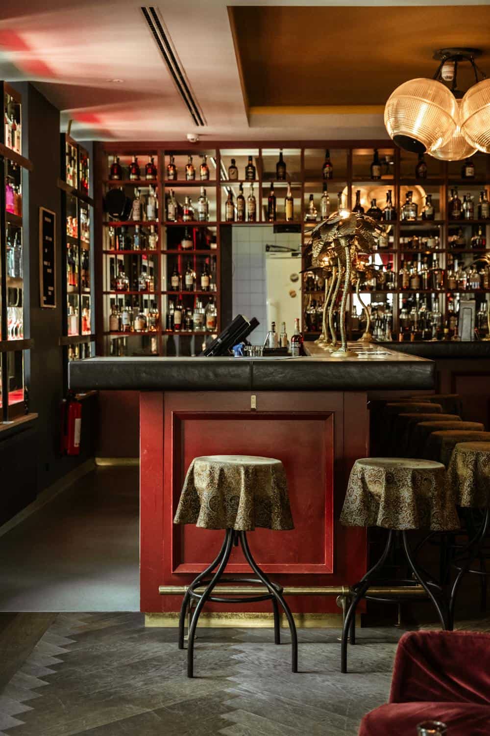 Luxurious cocktail bar interior in Munich, Germany with plush seating and premium spirits.